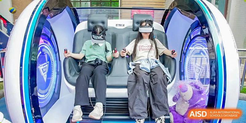 Two female students sitting in moving simulation chairs while wearing virtual reality (VR) headsets during a school event at Changsha WES (Bilingual) Academy.