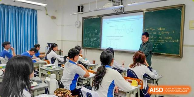 Students attending a lesson with equations projected onto a large blackboard at Shenzhen Third Senior High School International Division A-Level Class.