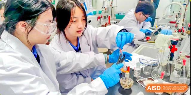 Female student in gloves and lab coat working with scientific equipment in a lab at Shenzhen Third Senior High School International Division A-Level Class.
