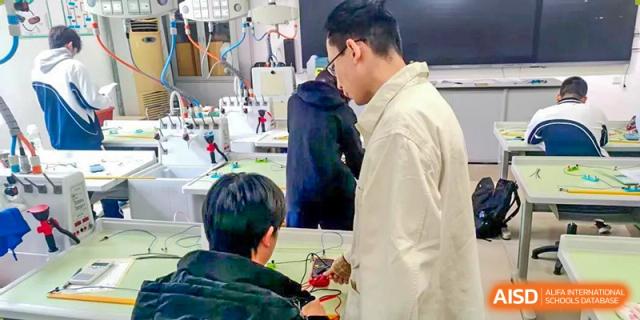 Students and a teacher or instructor discussing a project in a classroom or lab at Shenzhen Third Senior High School International Division A-Level Class.