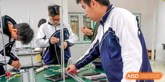 Students working together on a practical science or engineering project using metal rods and equipment at Shenzhen Third Senior High School International Division A-Level Class.