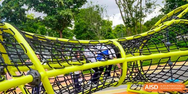 Student crawling through an outdoor netted playground structure during a recreational activity at Shenzhen Third Senior High School International Division A-Level Class.