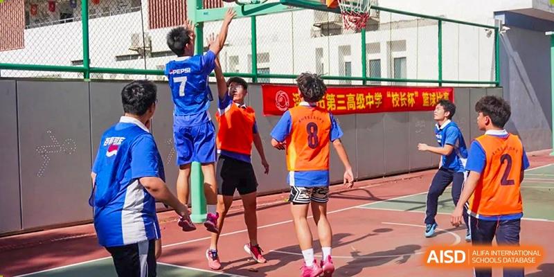 Students playing basketball in a competitive game on an outdoor court at Shenzhen Third Senior High School International Division A-Level Class.