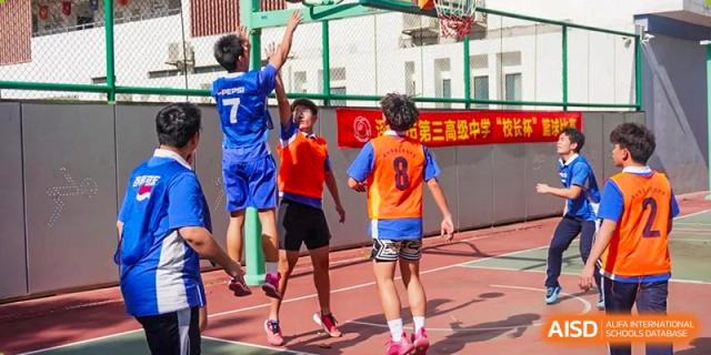 Students playing basketball in a competitive game on an outdoor court at Shenzhen Third Senior High School International Division A-Level Class.