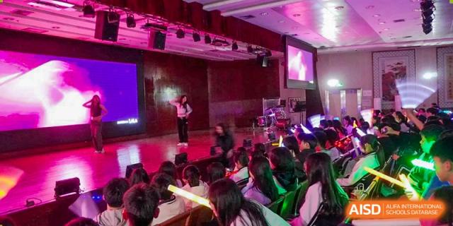 Students attending a brightly lit indoor performance or event at Shenzhen Third Senior High School International Division A-Level Class.
