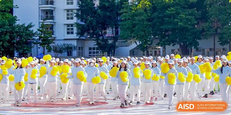 Group of students in white outfits marching and holding yellow balloons at an outdoor event at Shenzhen Third Senior High School International Division A-Level Class.