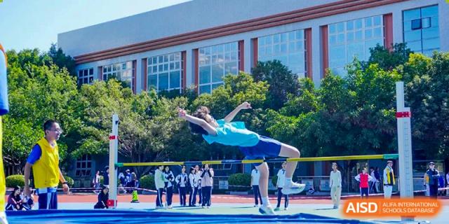 Student performing a high jump during a track and field competition at Shenzhen Third Senior High School International Division A-Level Class.