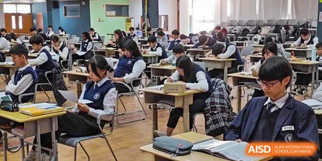 Students seated at individual desks in a busy classroom setting at Weihai Zhongshi Foreign School (WZFS).