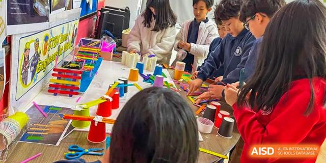Students participating in a hands-on art or craft activity, viewed from above at Weihai Zhongshi Foreign School (WZFS).