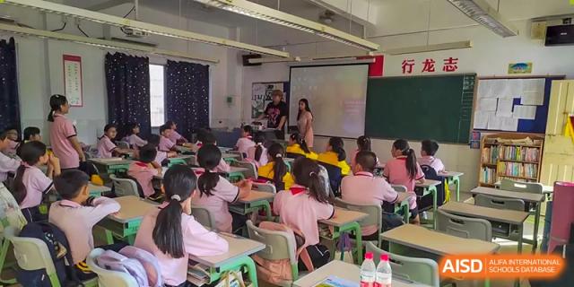 A teacher standing at the front of a classroom, giving a lesson to students at Alcanta International College.