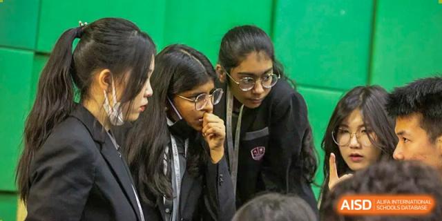 A close-up of two female students talking and looking at something with a focused expression at Alcanta International College.