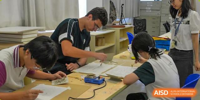 A male student using a soldering iron for a hands-on project in a workshop or class at Alcanta International College.