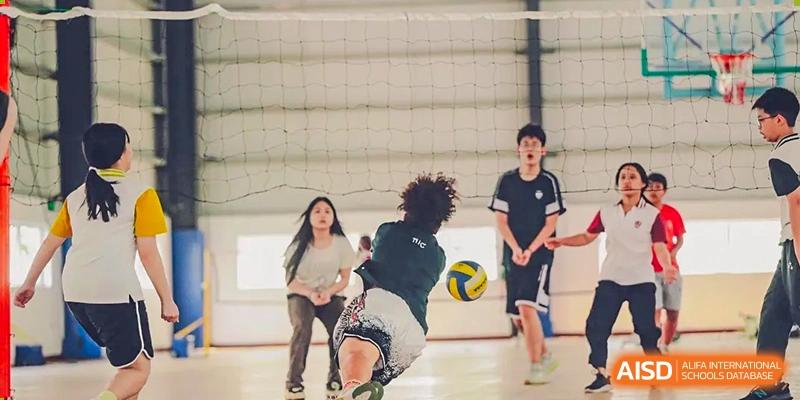 A female student hitting a volleyball during an indoor game at Alcanta International College.