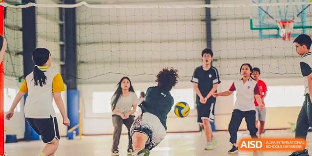 A female student hitting a volleyball during an indoor game at Alcanta International College.