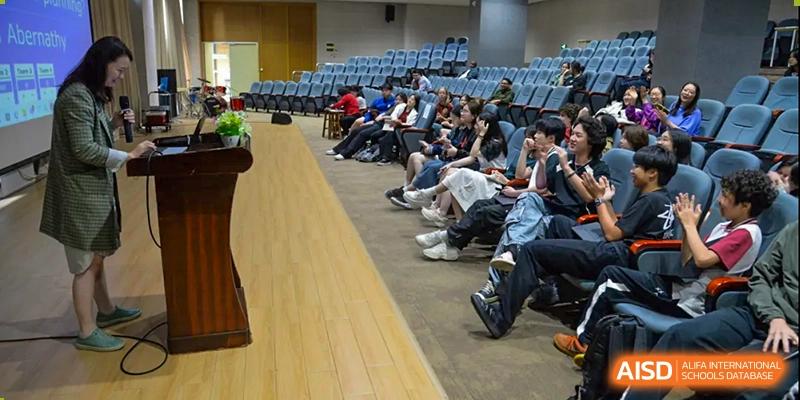 Students sitting in an auditorium, listening to a presentation or performance at Alcanta International College.
