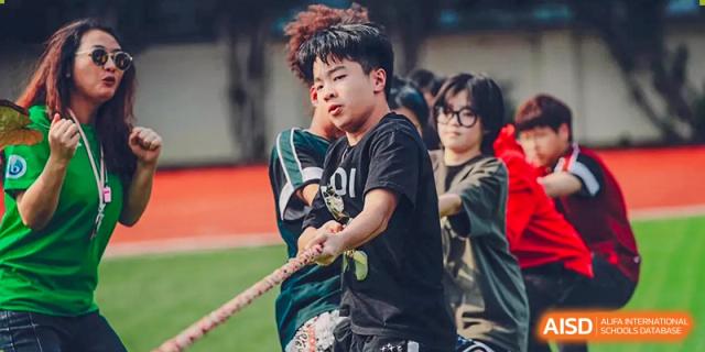 A male student pulling hard on a rope during a tug-of-war competition at Alcanta International College.