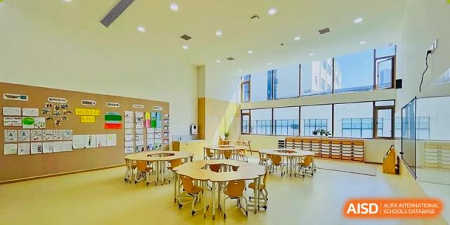 A bright, modern classroom at Changsha BeeMee Forest School (CBFS) with small round tables and chairs.