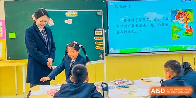 Students from Changsha BeeMee Forest School (CBFS) interacting with a teacher and a large digital screen in a classroom setting.