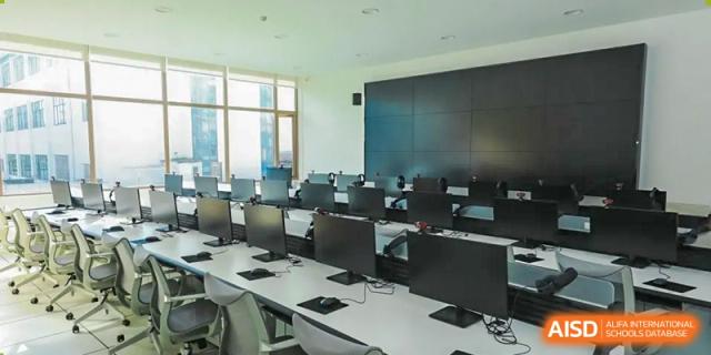 A clean, bright computer lab at Changsha BeeMee Forest School (CBFS) with rows of desktop computers.