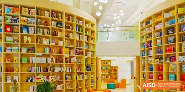 The colorful library or reading area at Changsha BeeMee Forest School (CBFS), featuring curved bookshelves and a bright interior.