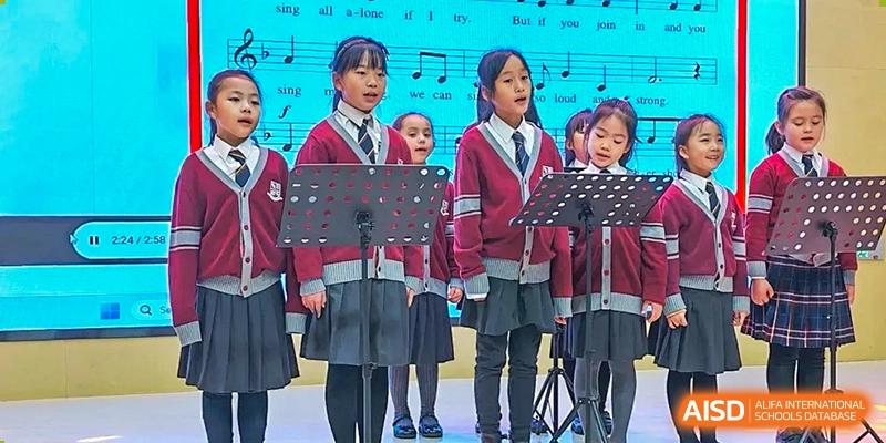 Students from Changsha BeeMee Forest School (CBFS) wearing school uniforms and performing in a choir or singing group.
