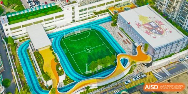 An aerial view of the vibrant blue and green outdoor football pitch and track at Changsha BeeMee Forest School (CBFS).