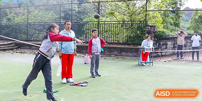 CHONGQING WEIMING SCHOOL student practicing basketball outdoors with an instructor on a green court.