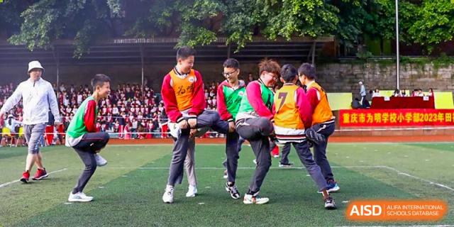 Group of CHONGQING WEIMING SCHOOL students participating in a lively sports day activity or game on a field.