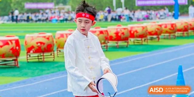 A CHONGQING WEIMING SCHOOL student dressed in traditional Chinese attire (Tang suit/Hanfu), possibly for a performance or ceremony.