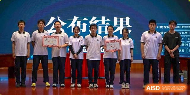 A group of award-winning students from Dalian No.24 High School Cambridge International A-Level Centre stand together, holding certificates or plaques.