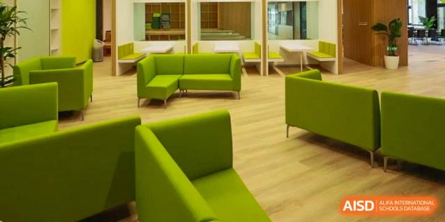 A clean and modern student common area or lounge with bright green couches and soft seating at Dehong International Chinese School.