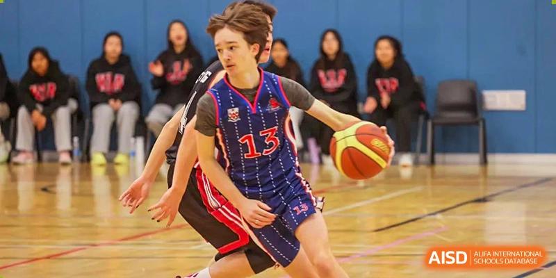A student from Dulwich College Shanghai Puxi with jersey number 13 playing basketball.