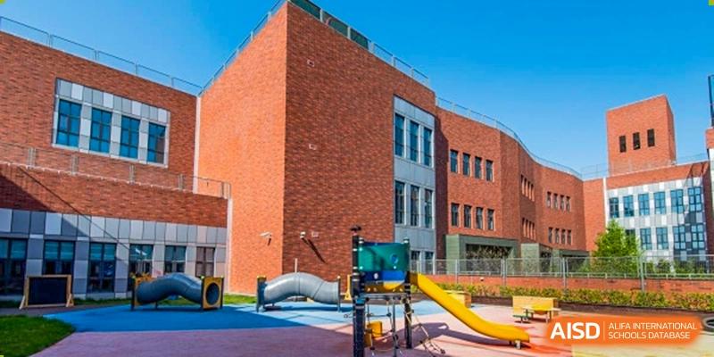 The exterior of a building at Dulwich College Shanghai Puxi with a playground.