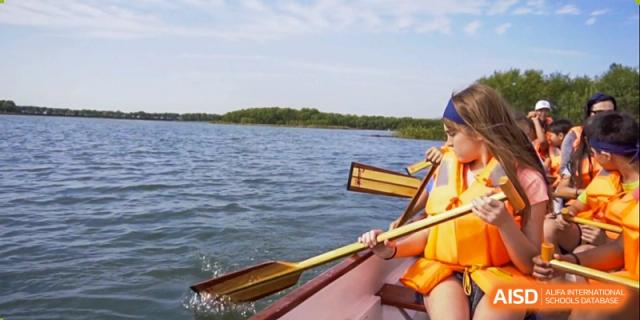 Two people are paddling a canoe on a lake at Dulwich College Suzhou.