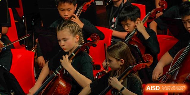 Students from Dulwich College Suzhou are playing cello in an orchestra.