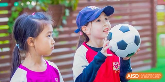 A young Dulwich College Suzhou student looks up with a curious expression.