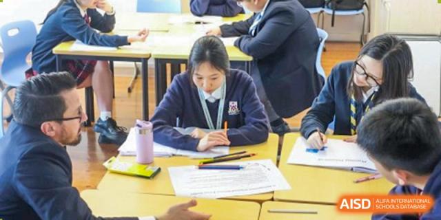 A female student from Dulwich International Suzhou High School Programme working on an assignment at her desk.