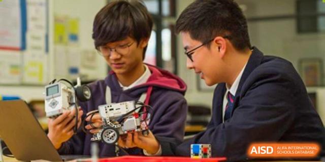 Two male students from Dulwich International Suzhou High School Programme working on a robotics project.