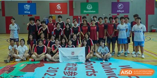 A group of students from Dulwich International Suzhou High School Programme posing for a team photo with a banner.
