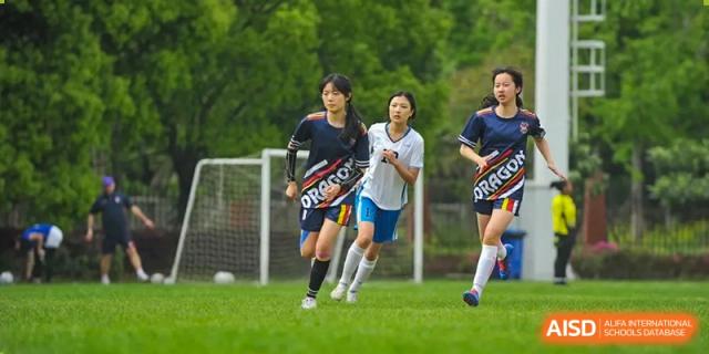 Students from Dulwich International Suzhou High School Programme playing soccer on a field.