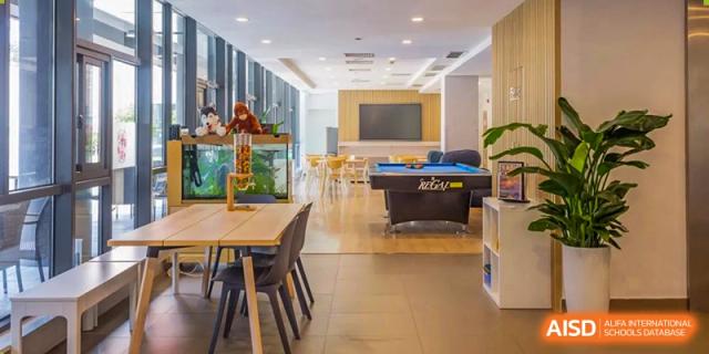 A common area in a dormitory at Dulwich International Suzhou High School Programme with a pool table and tables for studying or dining.