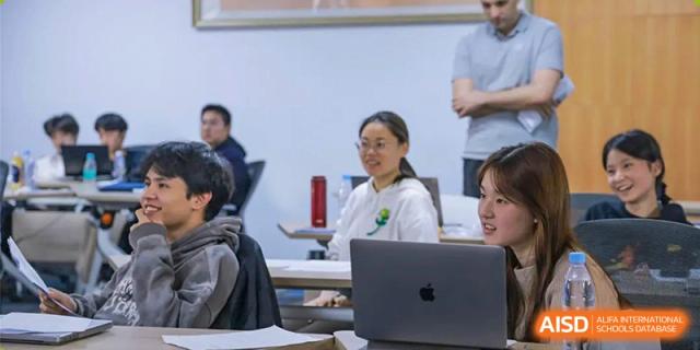 A teacher using a laptop in a classroom at Fuzhou Lakeside International School.
