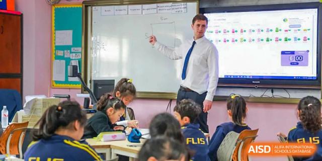 A male teacher writing on a whiteboard for students in a classroom at Fuzhou Lakeside International School.
