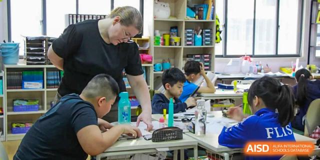 A teacher providing one-on-one help to a student at their desk at Fuzhou Lakeside International School.