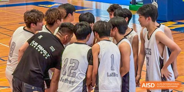 The boys' basketball team huddling together during a game at Fuzhou Lakeside International School.