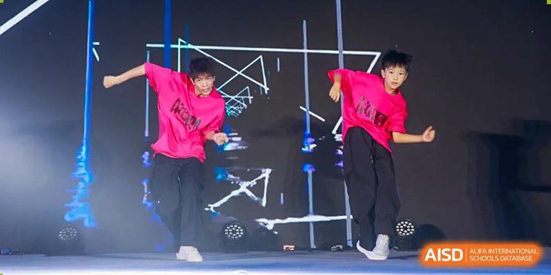 Performers on a stage with bright pink and blue lighting at an event for Fuzhou Lakeside International School.