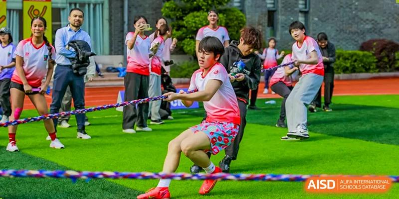 A student with a determined expression during a tug-of-war game at Fuzhou Lakeside International School.