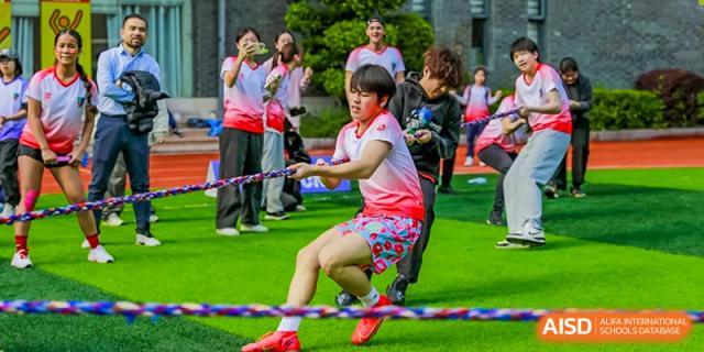A student with a determined expression during a tug-of-war game at Fuzhou Lakeside International School.
