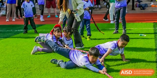 A student who has fallen on the ground during a tug-of-war match at Fuzhou Lakeside International School.