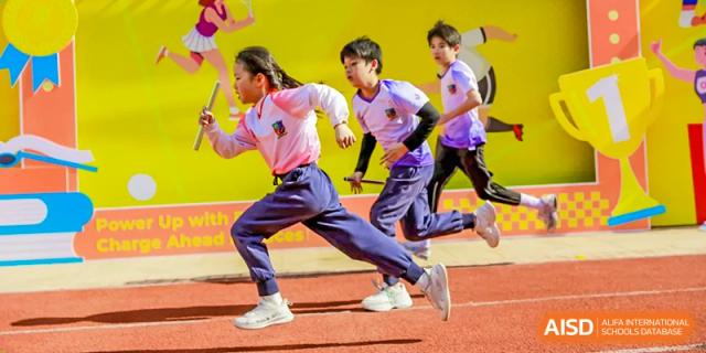 Students running energetically on a track during a race at Fuzhou Lakeside International School.